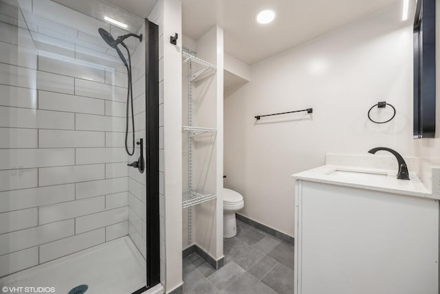 bathroom with a stall shower, baseboards, vanity, and toilet