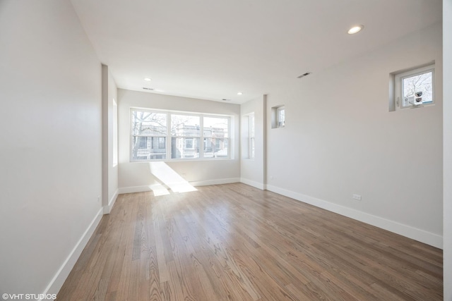 spare room featuring baseboards, wood finished floors, and recessed lighting