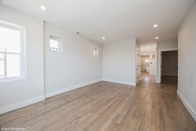 spare room featuring recessed lighting, light wood-style flooring, and baseboards