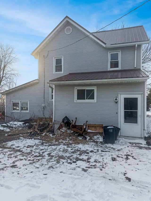 snow covered property featuring metal roof