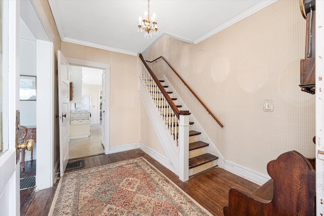 staircase featuring an inviting chandelier, crown molding, baseboards, and wood finished floors