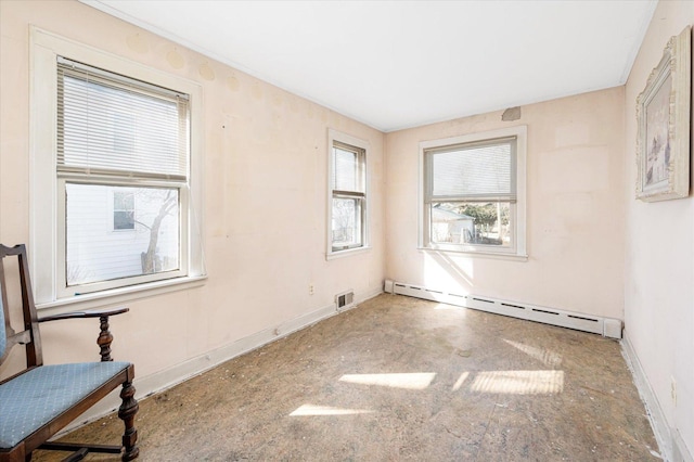 spare room featuring baseboards, visible vents, and a baseboard heating unit