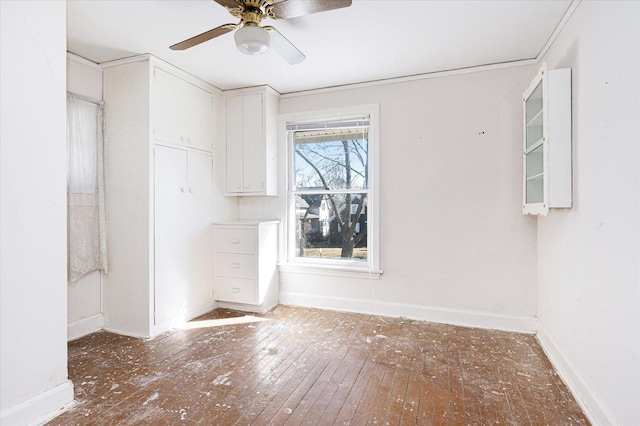 unfurnished dining area with wood-type flooring, baseboards, and a ceiling fan