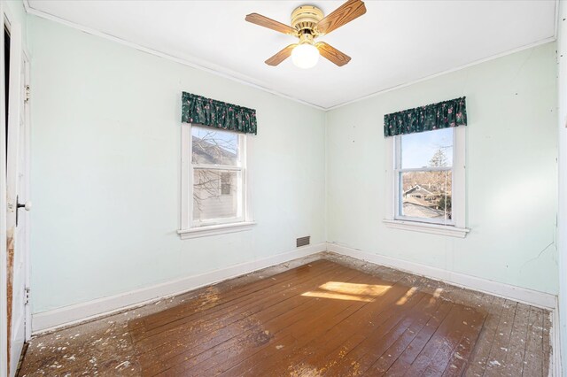 unfurnished room featuring hardwood / wood-style floors, visible vents, and crown molding