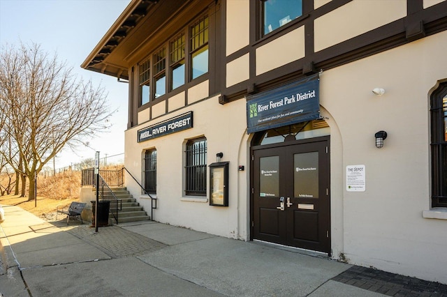 view of exterior entry with french doors and stucco siding