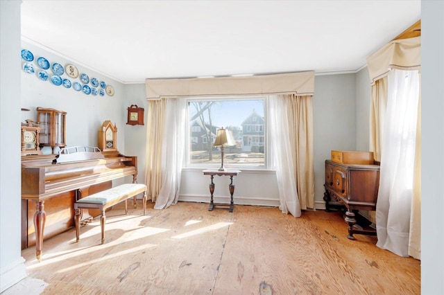 living area featuring baseboards and ornamental molding