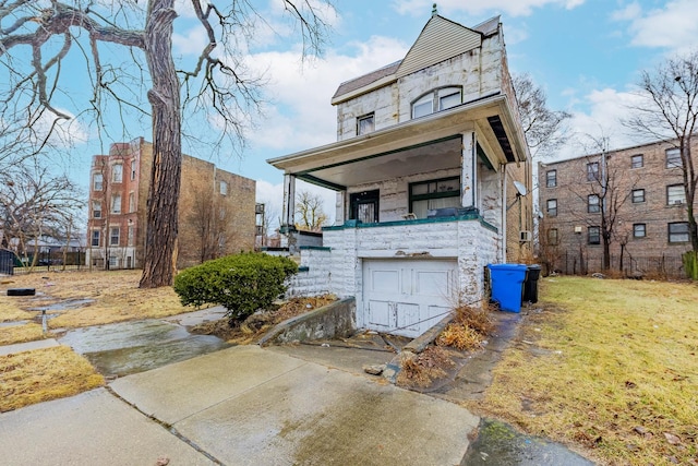 view of front of property featuring an attached garage, concrete driveway, and a front yard