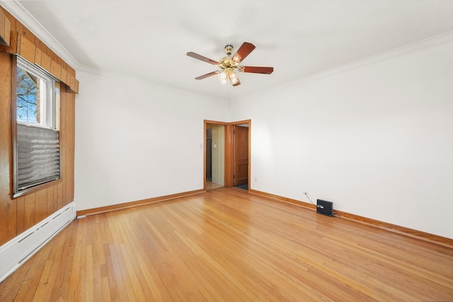 empty room featuring light wood finished floors, baseboards, a ceiling fan, a baseboard radiator, and crown molding