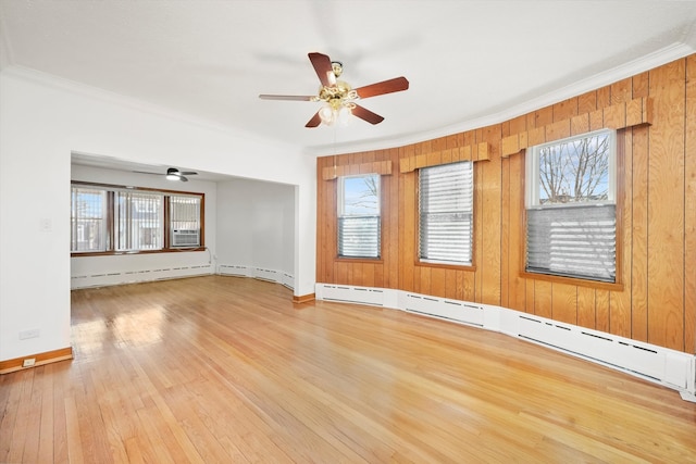 spare room with baseboards, a ceiling fan, a baseboard radiator, wood-type flooring, and ornamental molding