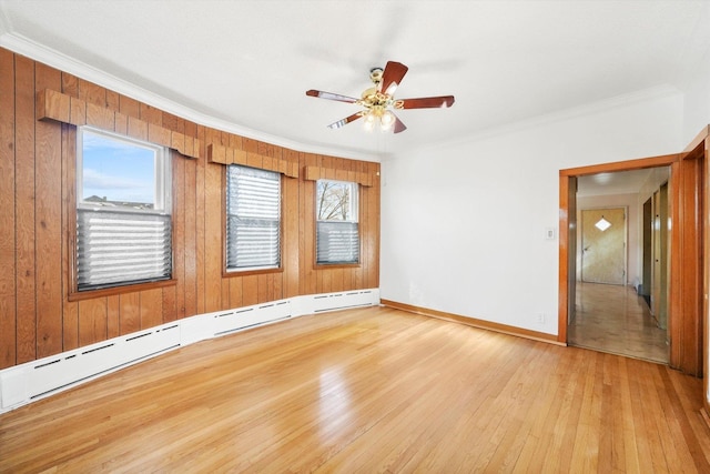 spare room featuring a ceiling fan, baseboards, light wood-style floors, ornamental molding, and baseboard heating