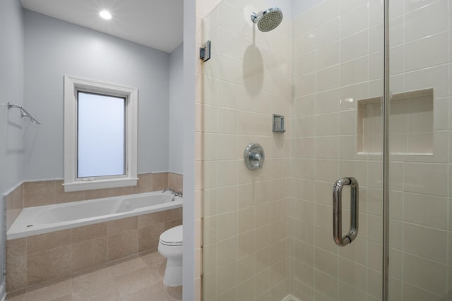 bathroom featuring a stall shower, tile patterned flooring, a garden tub, and toilet