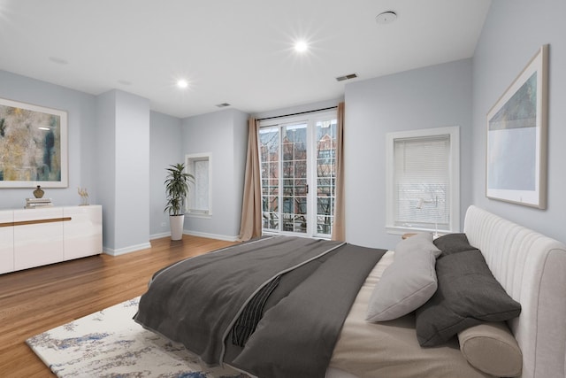 bedroom with light wood finished floors, baseboards, visible vents, and recessed lighting