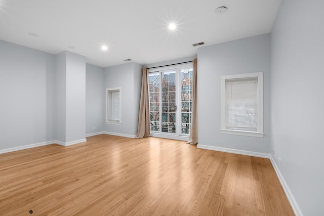 unfurnished room featuring light wood-type flooring, visible vents, baseboards, and recessed lighting