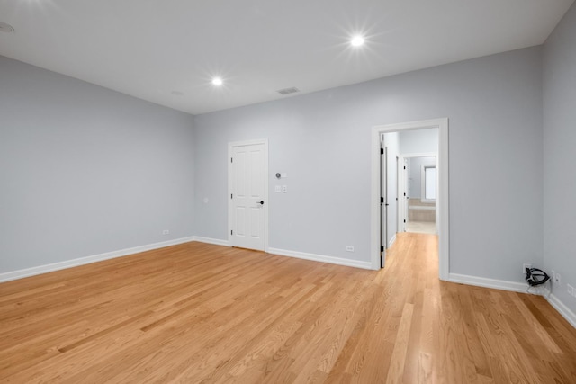 empty room with light wood finished floors, baseboards, and recessed lighting