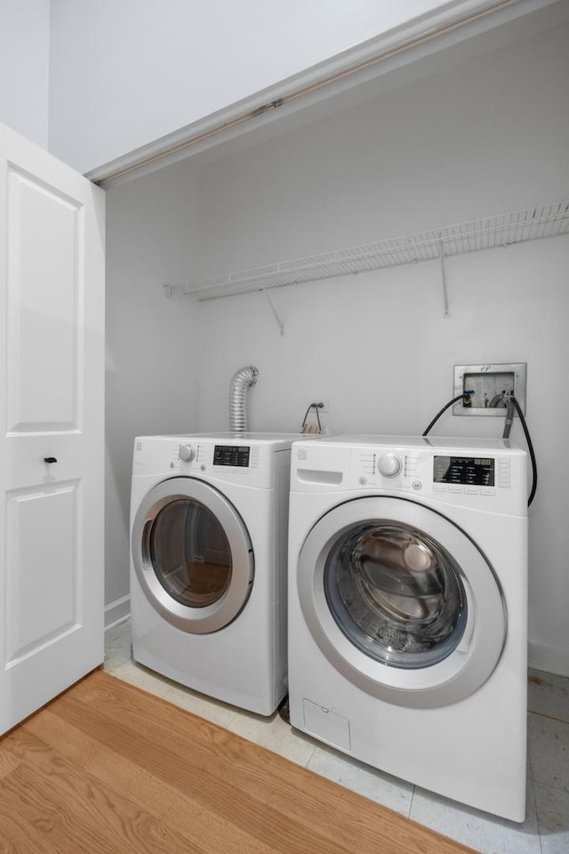 laundry area featuring laundry area, light tile patterned floors, baseboards, and washing machine and clothes dryer