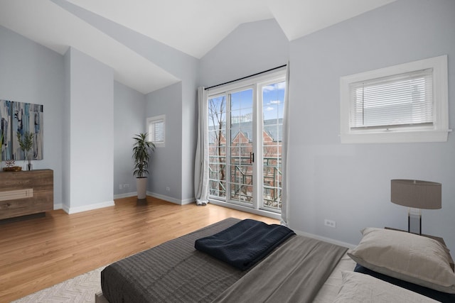 bedroom with vaulted ceiling, baseboards, and wood finished floors