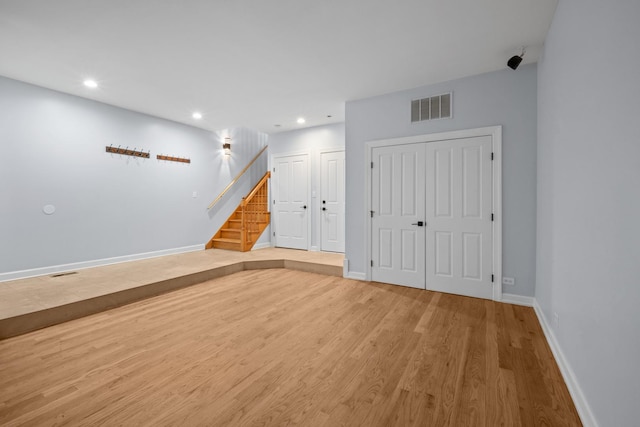 interior space featuring recessed lighting, visible vents, stairway, wood finished floors, and baseboards