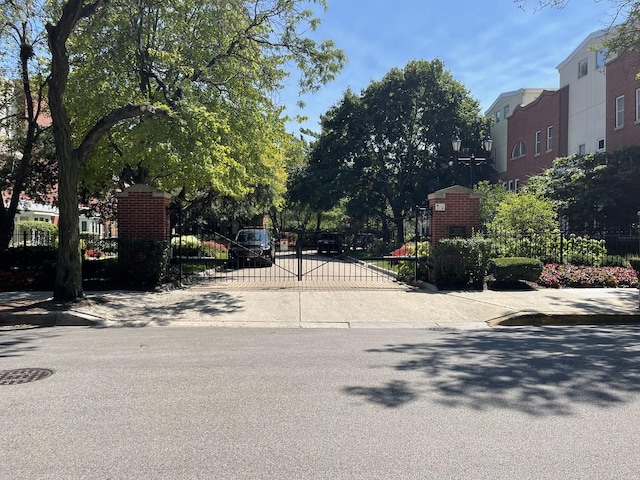 view of street featuring a gate and curbs