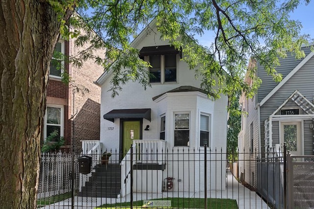 view of front of home featuring a fenced front yard, a gate, and brick siding