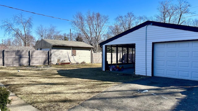 garage featuring driveway and fence