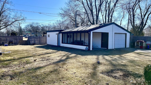 detached garage featuring fence and driveway