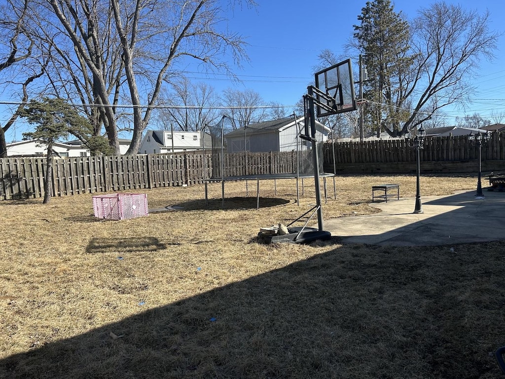 view of yard featuring a trampoline and a fenced backyard