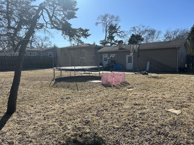 view of yard featuring a trampoline and fence