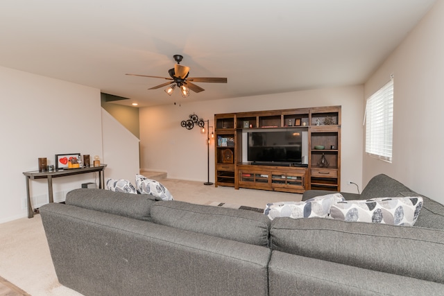 living area with carpet floors, baseboards, and a ceiling fan