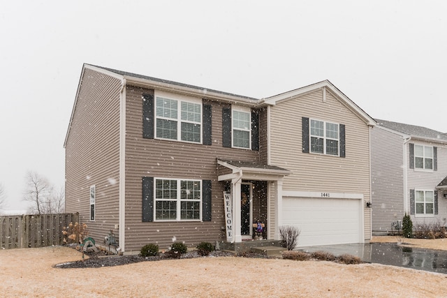 traditional home featuring aphalt driveway, an attached garage, and fence