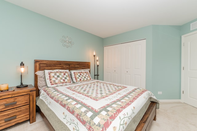 carpeted bedroom with a closet and baseboards