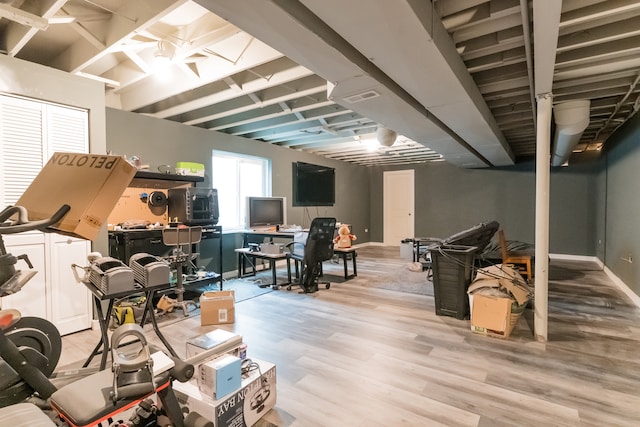 basement featuring visible vents, baseboards, and wood finished floors