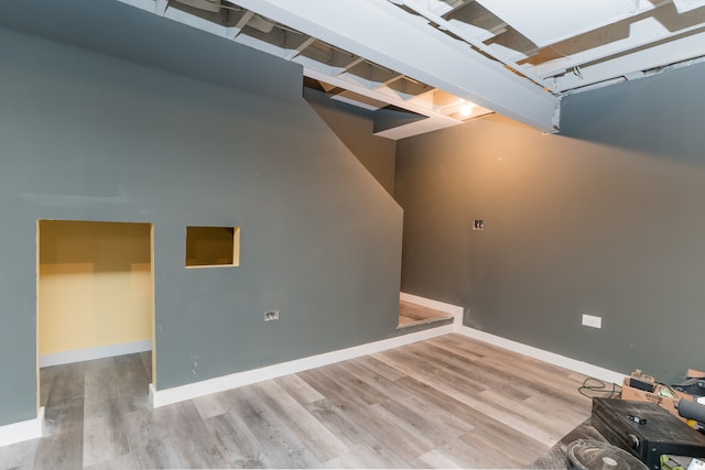 below grade area featuring baseboards and wood finished floors