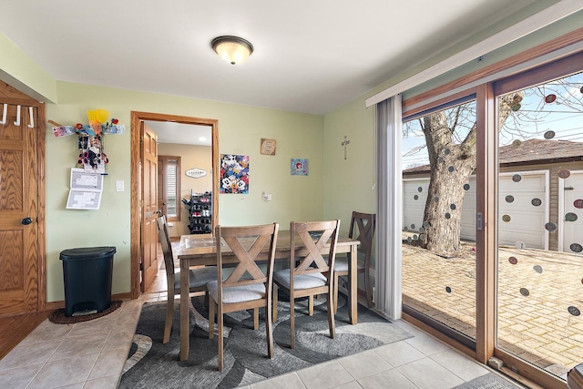 dining space featuring light tile patterned flooring and baseboards