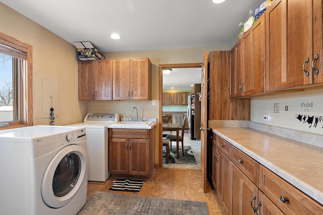 laundry room featuring light floors, recessed lighting, washer and dryer, cabinet space, and a sink