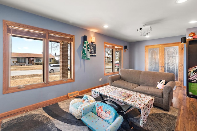 living room featuring recessed lighting, baseboards, and wood finished floors