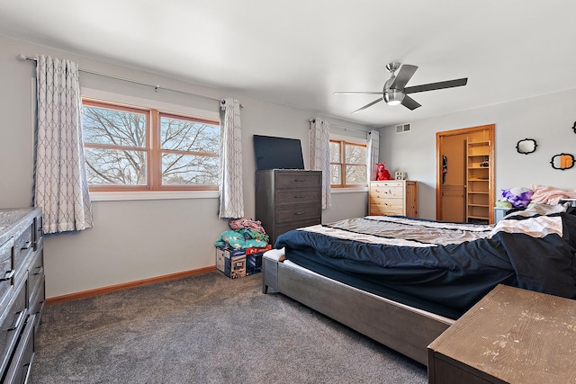 bedroom featuring visible vents, a walk in closet, a ceiling fan, carpet flooring, and baseboards