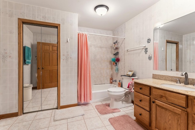 bathroom featuring toilet, tile walls, shower / bath combination with curtain, and tile patterned flooring