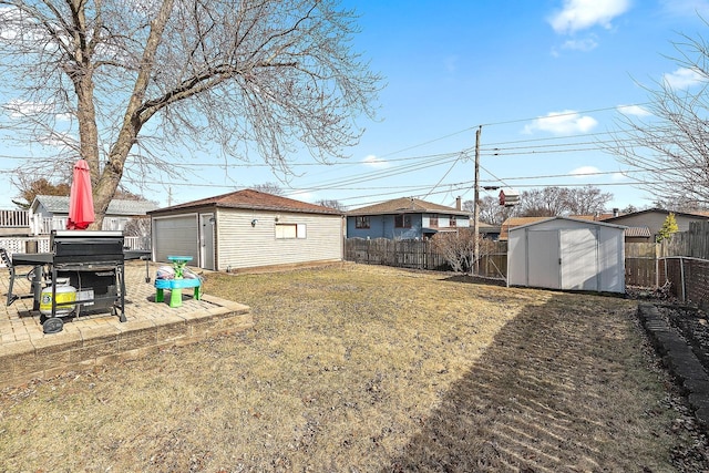 view of yard with an outdoor structure, a fenced backyard, and a detached garage