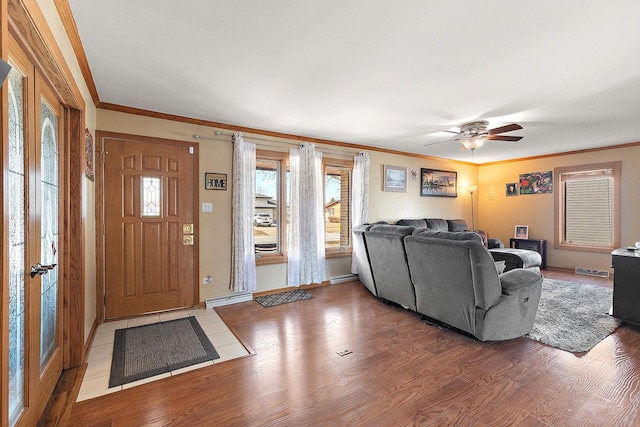 living room with crown molding, wood finished floors, and ceiling fan