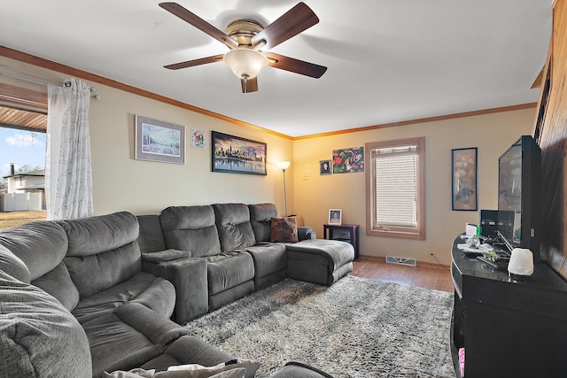 living room featuring visible vents, ceiling fan, crown molding, and light wood-style floors