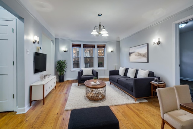 living room featuring light wood-type flooring, baseboards, a notable chandelier, and ornamental molding