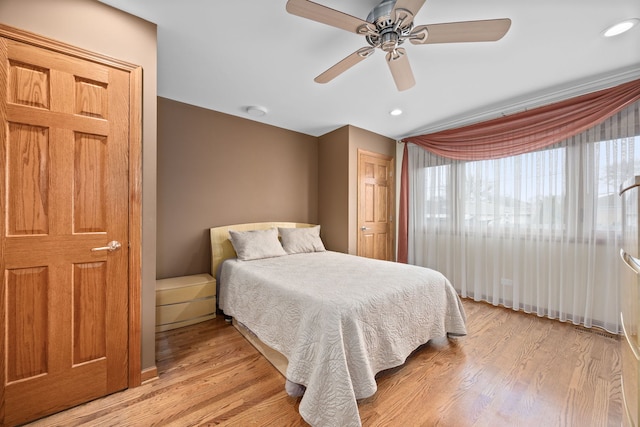 bedroom with light wood-type flooring, a ceiling fan, and recessed lighting