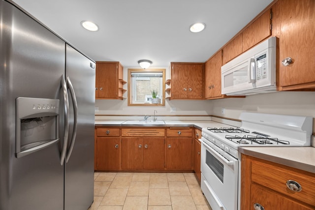 kitchen with brown cabinetry, white appliances, and a sink