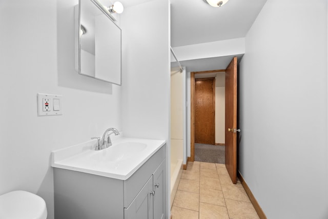 full bathroom featuring baseboards, toilet, tile patterned floors, walk in shower, and vanity