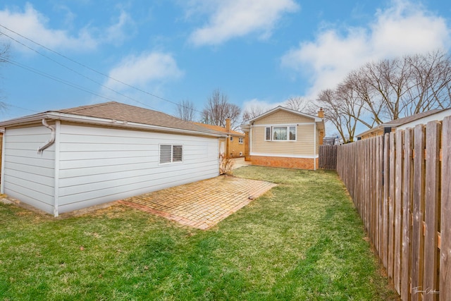 back of property featuring a patio area, a fenced backyard, roof with shingles, and a yard