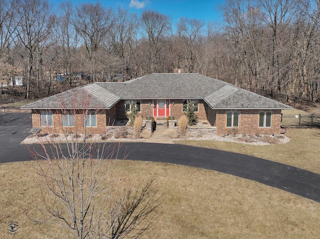 ranch-style house with brick siding, driveway, a front yard, and fence