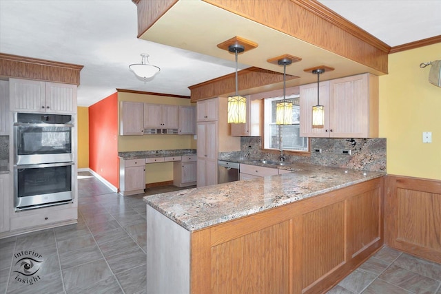 kitchen featuring light stone countertops, ornamental molding, appliances with stainless steel finishes, a peninsula, and a sink