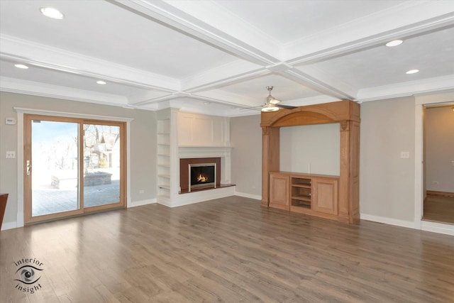 unfurnished living room with beam ceiling, a large fireplace, baseboards, and wood finished floors