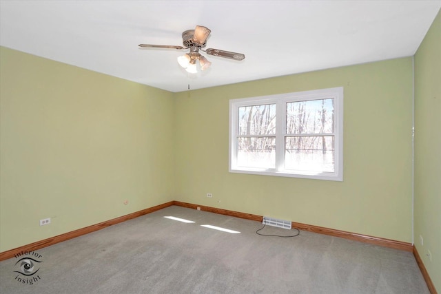 carpeted empty room featuring baseboards, visible vents, and ceiling fan