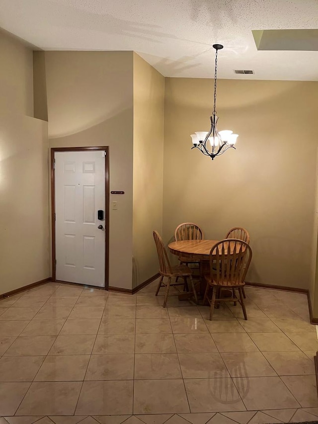 unfurnished dining area with light tile patterned floors, visible vents, baseboards, and an inviting chandelier